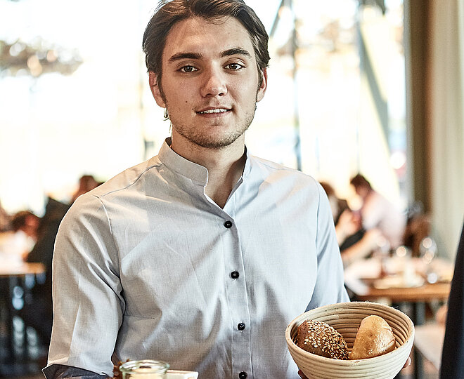 Bäckereifachverkäufer bedient Kunden