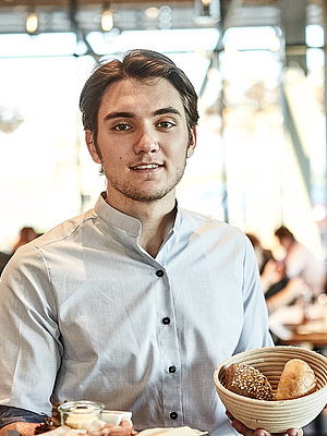 Bäckereifachverkäufer bedient Kunden