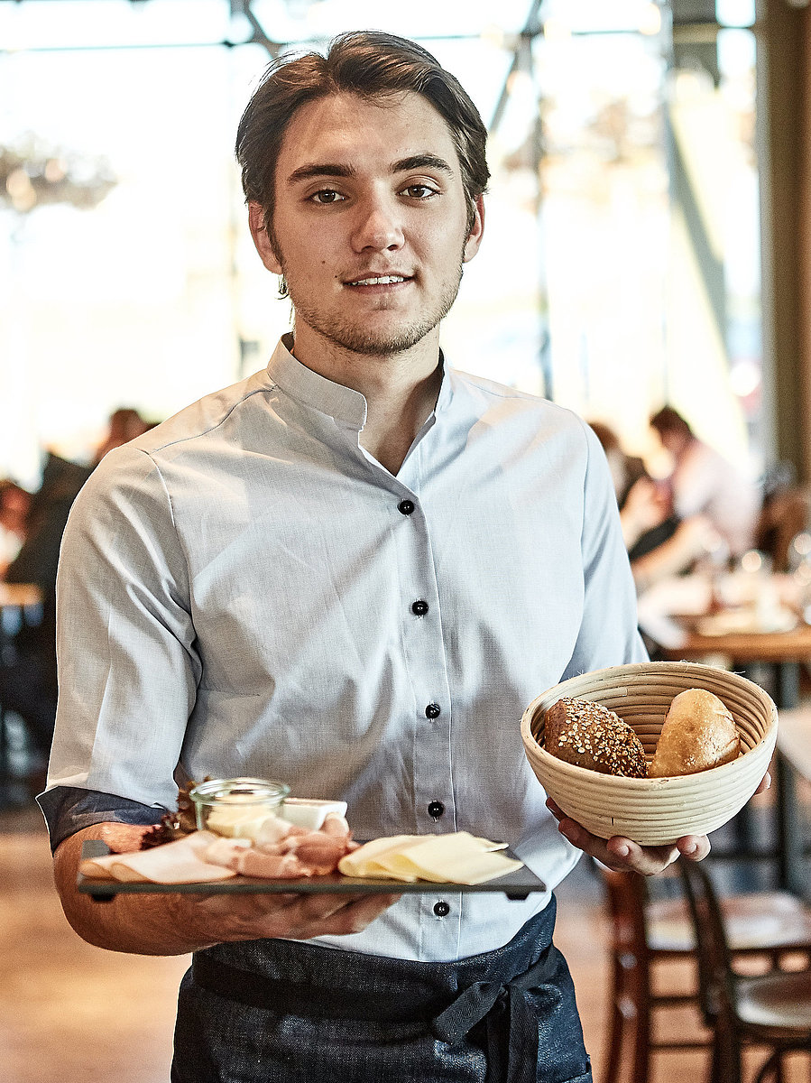 Bäckereifachverkäufer bedient Kunden
