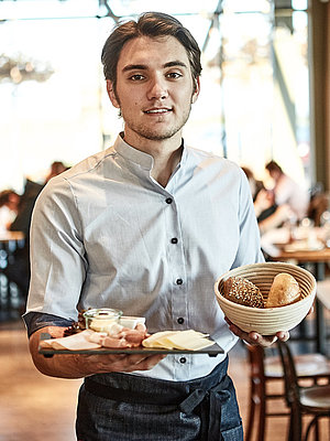 Bäckereifachverkäufer bedient Kunden