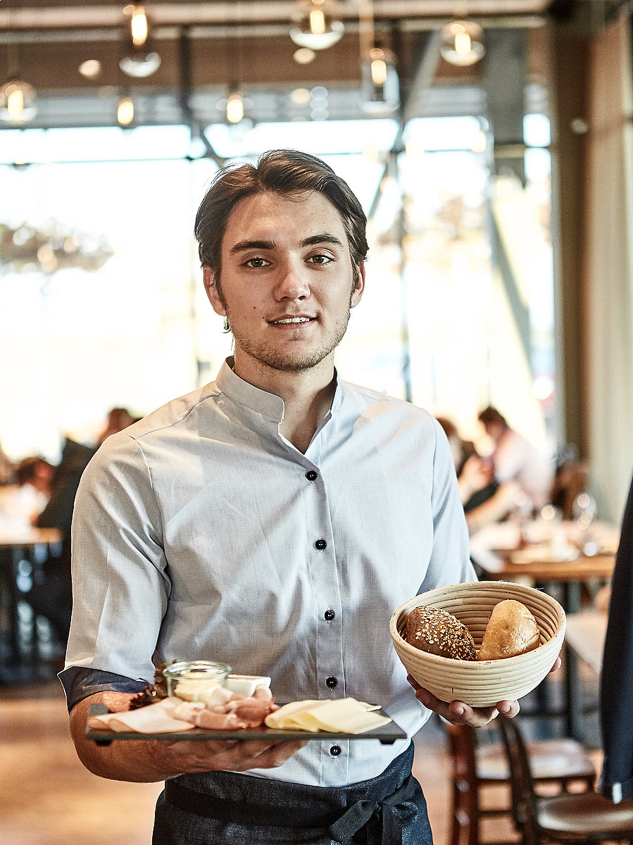 Bäckereifachverkäufer bedient Kunden