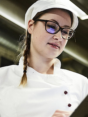 Bäckerin schreibt was auf ein Klemmbrett