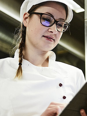 Bäckerin schreibt was auf ein Klemmbrett