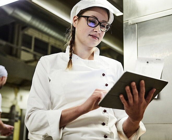 Bäckerin schreibt was auf ein Klemmbrett