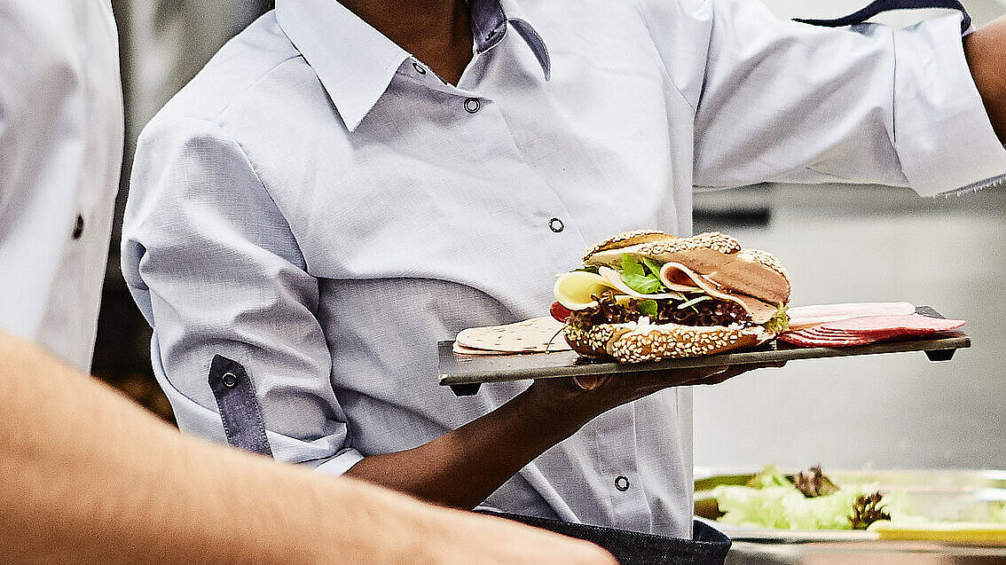 Mitarbeiter der Bäckerei Lutz beim Belegen von Brötchen