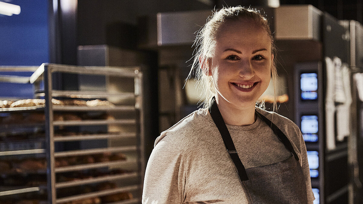Bäckereifachverkäuferin schaut in die Kamera