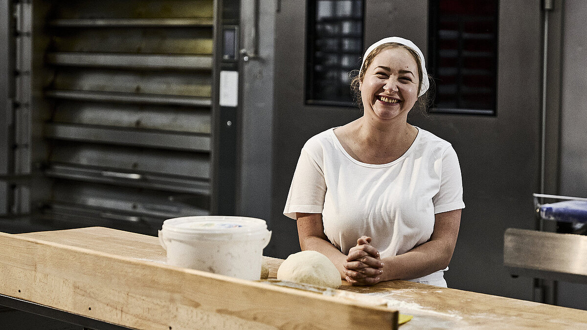 Bäckerin beim Teig kneten
