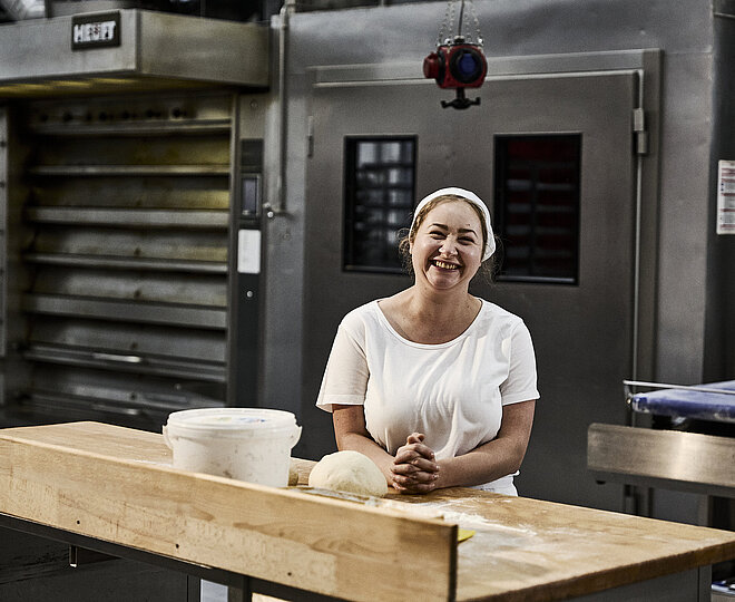 Bäckerin beim Teig kneten