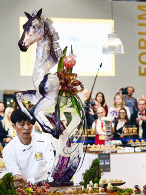 2 Bäcker mit einem Kunstwerk in Form eines Pferdes auf der Iba 2023