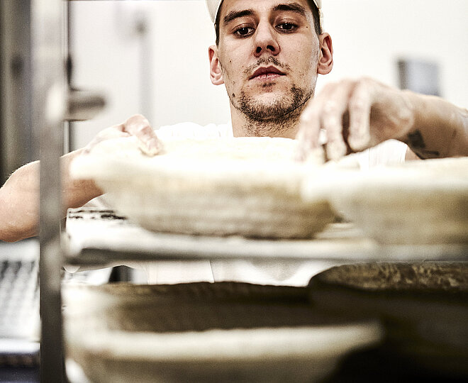 Bäcker prüft ein Gärkorb für Brote