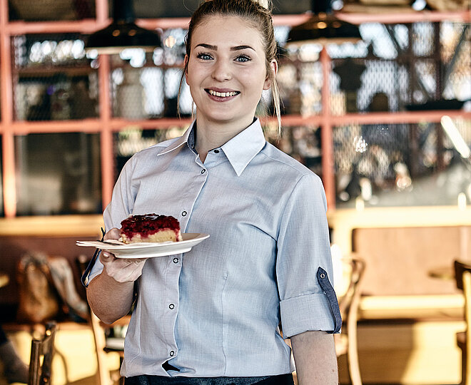 Bäckereifachverkäuferin hält Kuchen