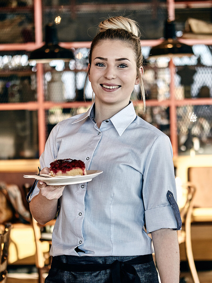 Bäckereifachverkäuferin hält Kuchen