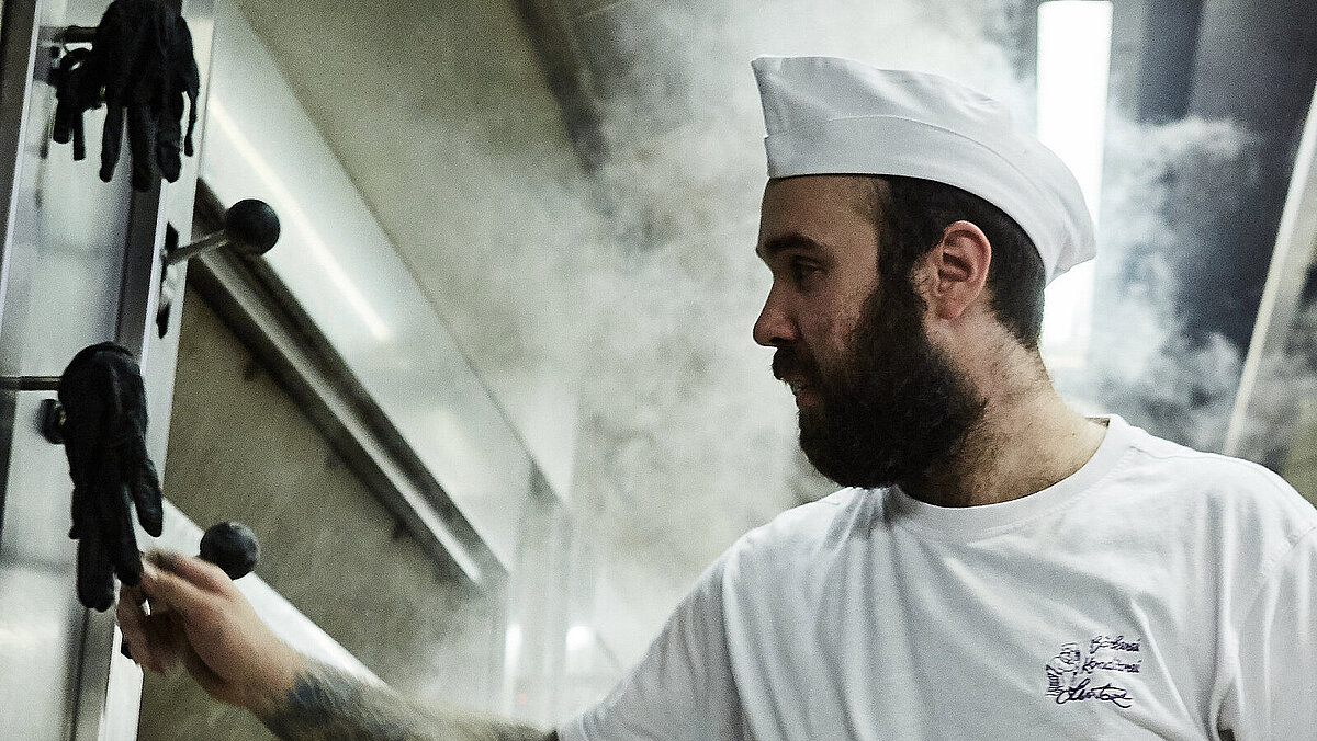 Bäcker prüft etwas am Ofen