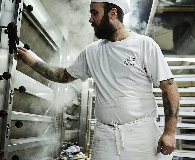 Bäcker prüft etwas am Ofen