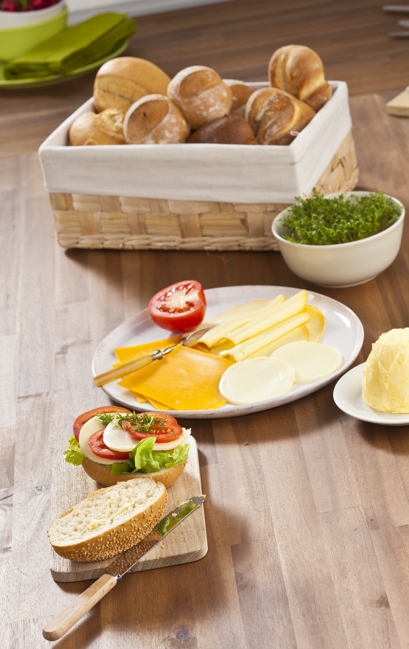 Frühstück mit frischen Brötchen, Käseaufschnitt und Salat