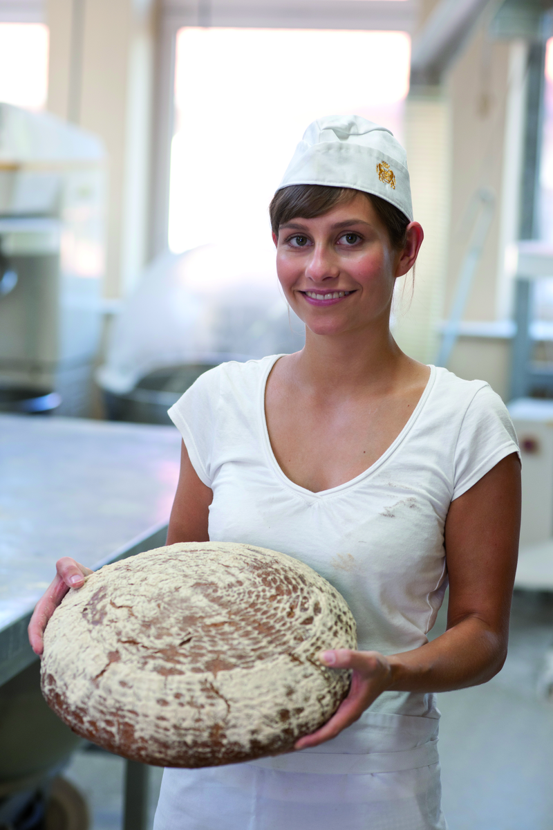 Auszubildende mit frisch gebackenem Brotlaib
