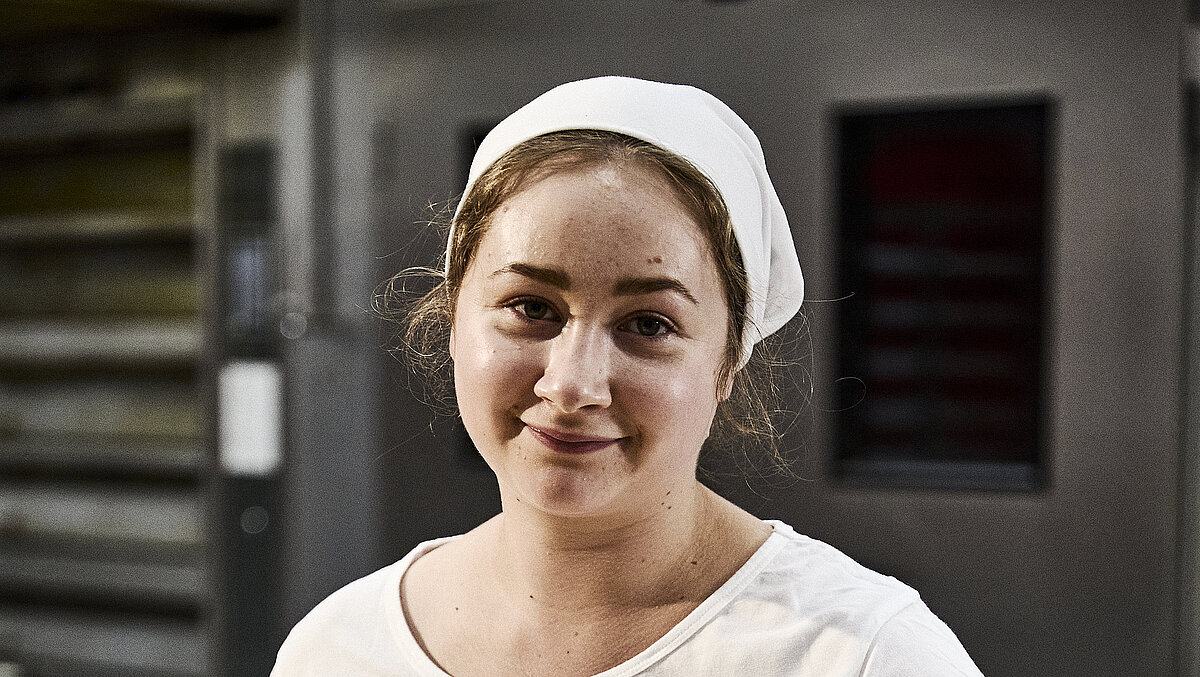 Bäckerin beim Teig kneten