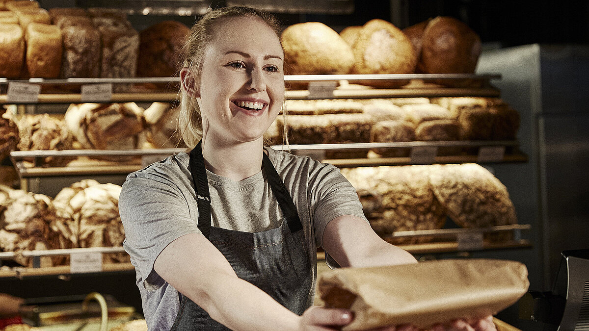Bäckereifachverkäuferin bedient Kunden