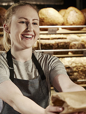 Bäckereifachverkäuferin bedient Kunden