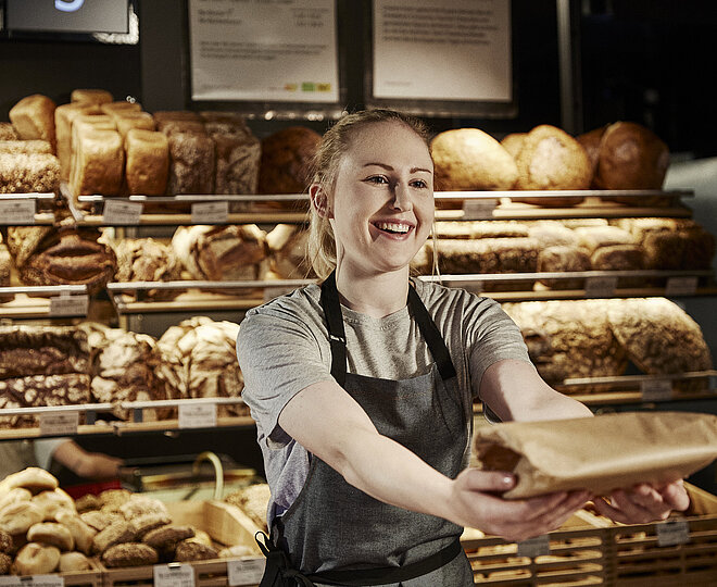 Bäckereifachverkäuferin bedient Kunden