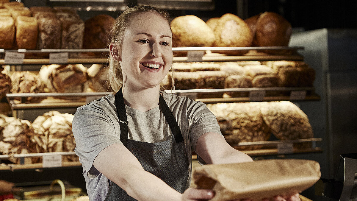 Bäckereifachverkäuferin bedient Kunden