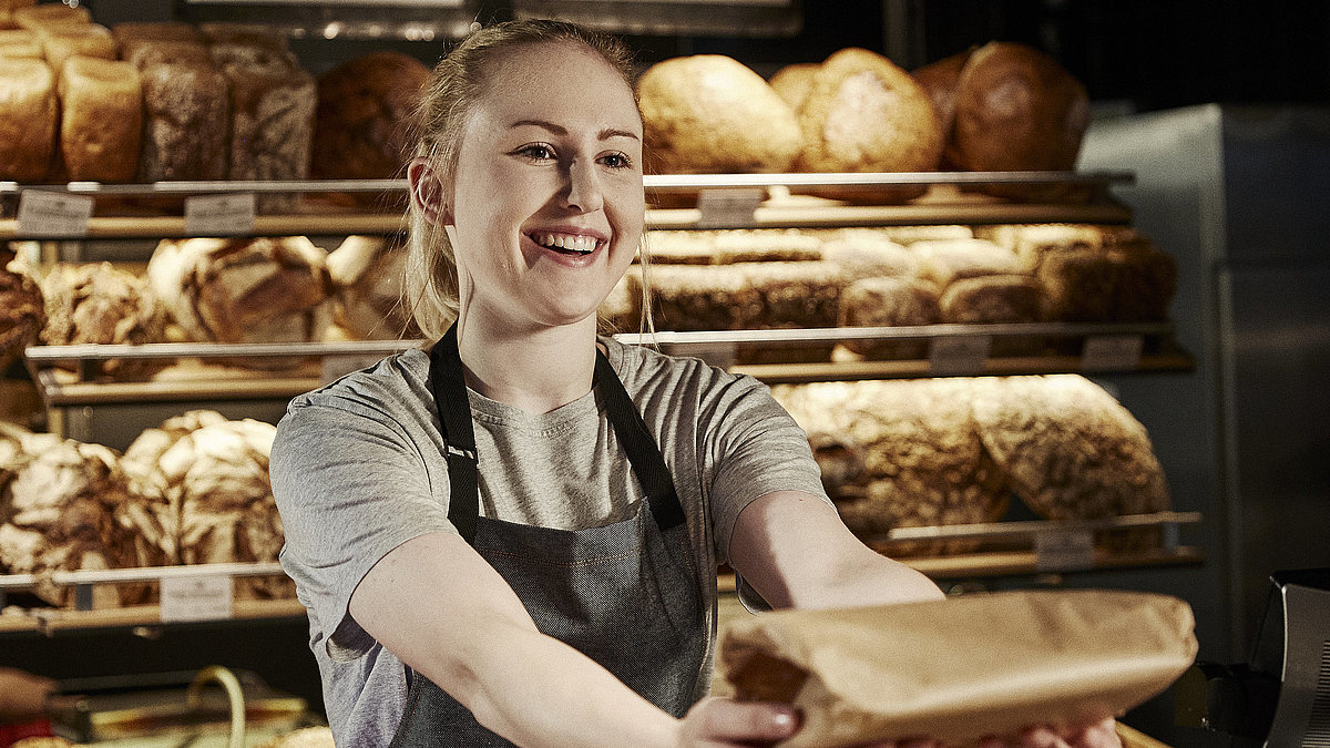 Bäckereifachverkäuferin bedient Kunden
