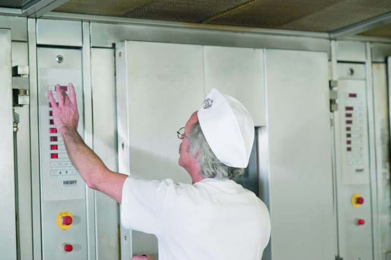 Bäckermeister stellt einen Backofen ein