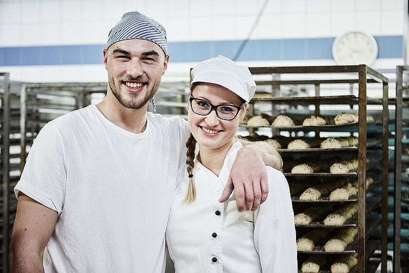 Bäckermeister und Azubine vor Stikkenwagen